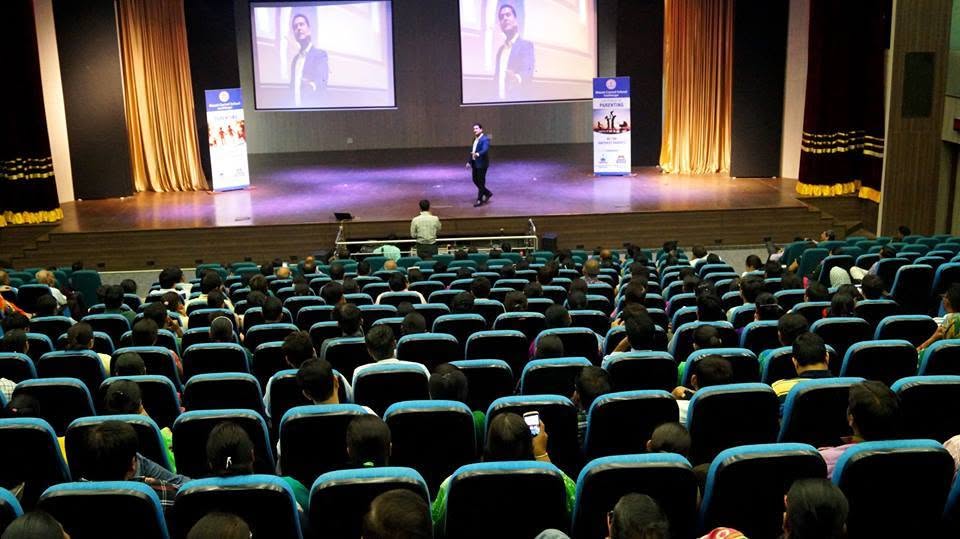 Parikshit Jobanputra parenting coach speaking on stage with his portrait on the screen Parikshit Jobanputra parenting coach speaking on stage with his portrait on the screen